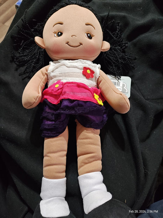 Doll with black hair wearing a white top and colorful skirt, perfect for imaginative play.