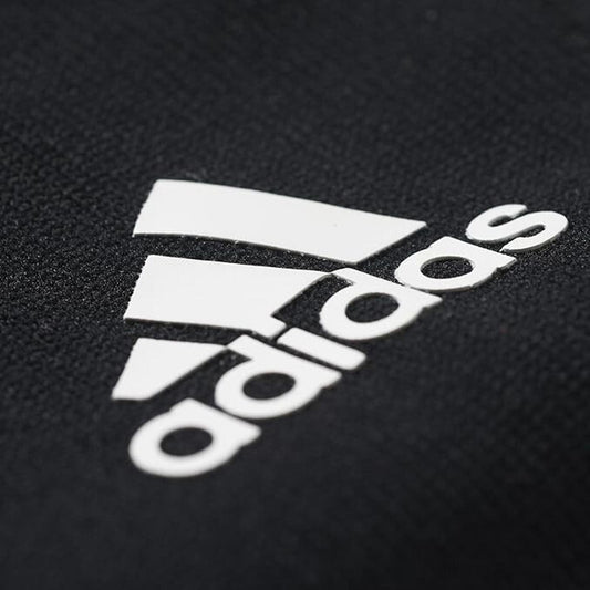 Adidas logo on a black fabric background, showcasing the iconic three stripes design.