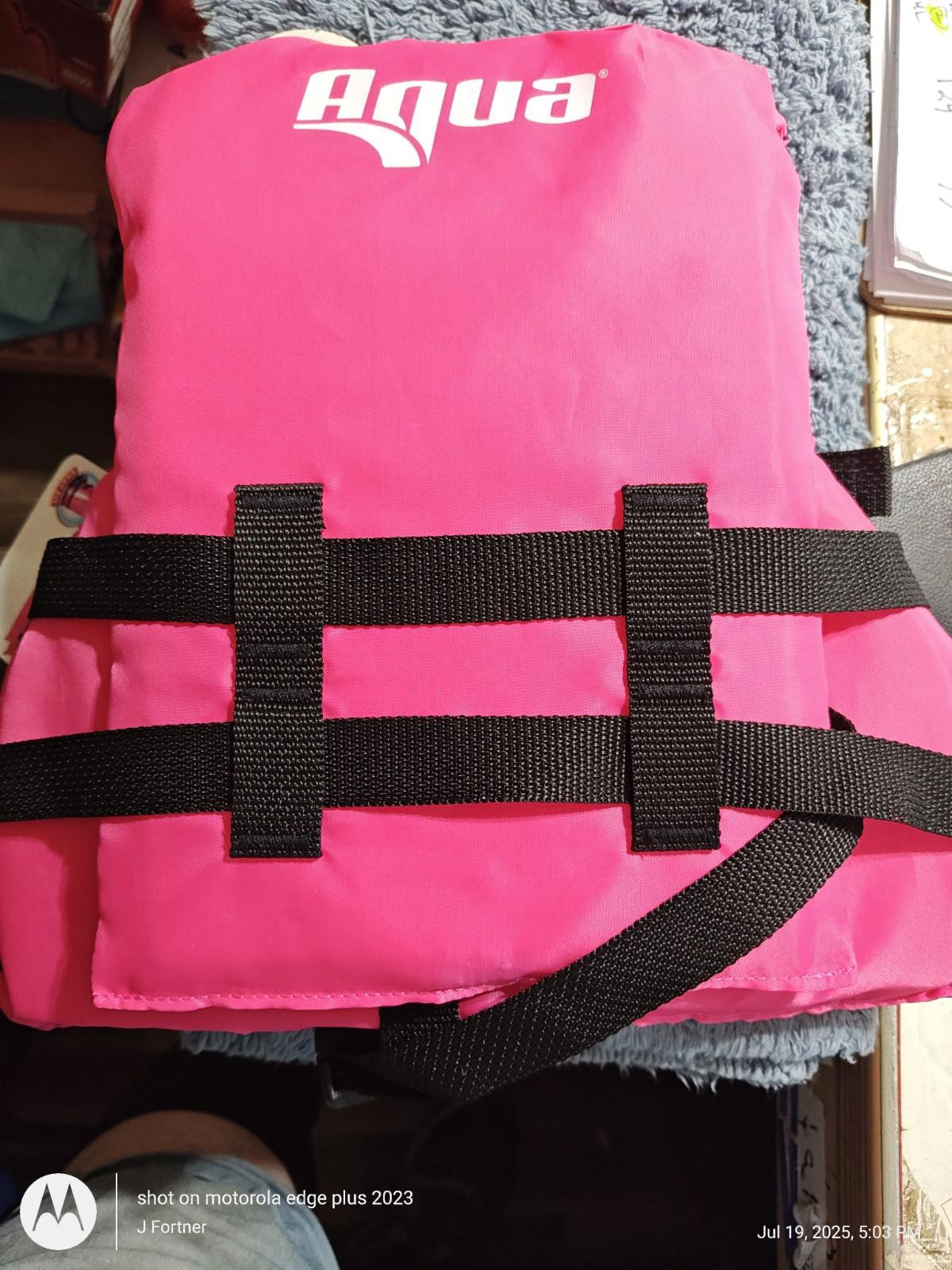 Aqua life jacket in bright pink color with black straps for safety.