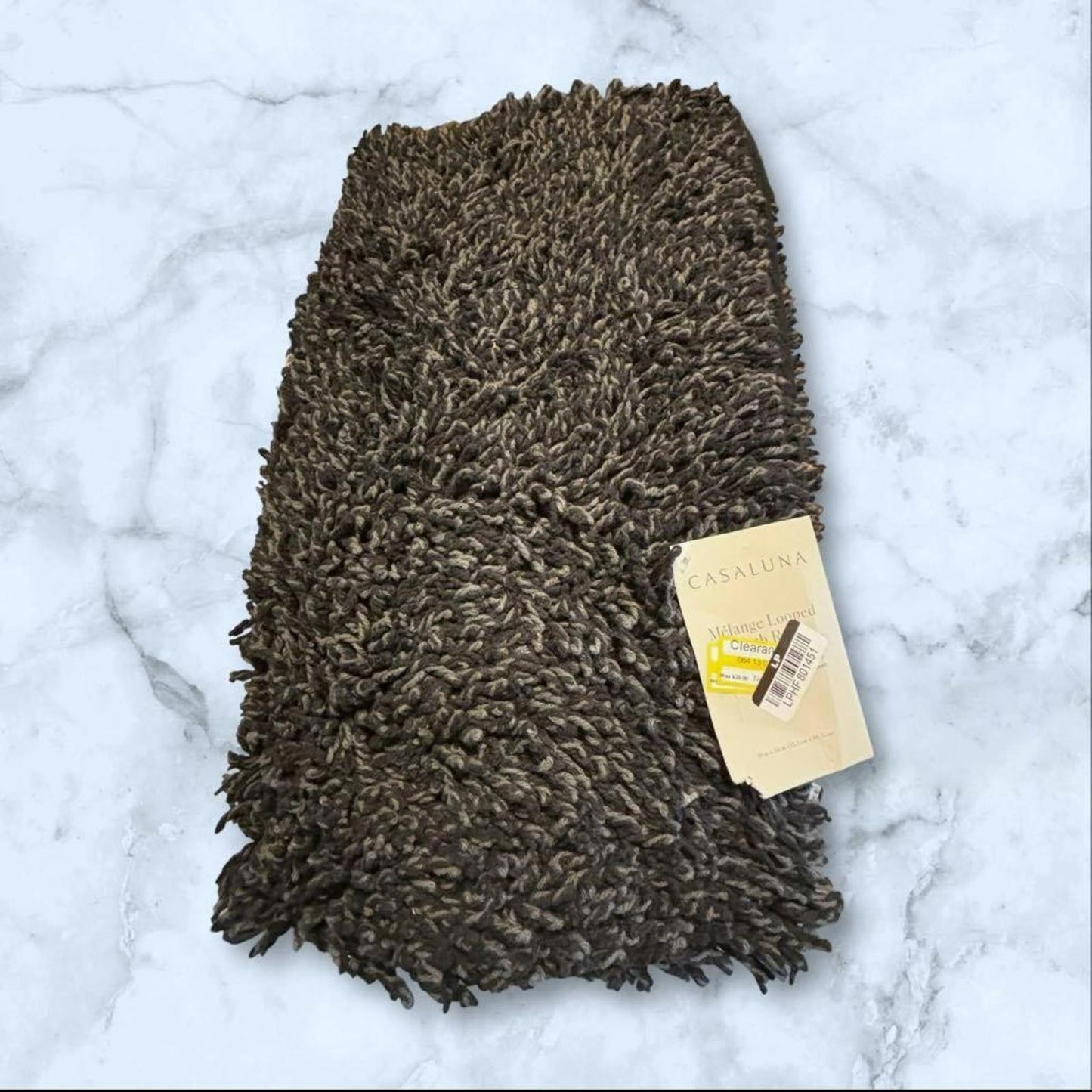 Brown shaggy area rug with a soft texture and tag attached.
