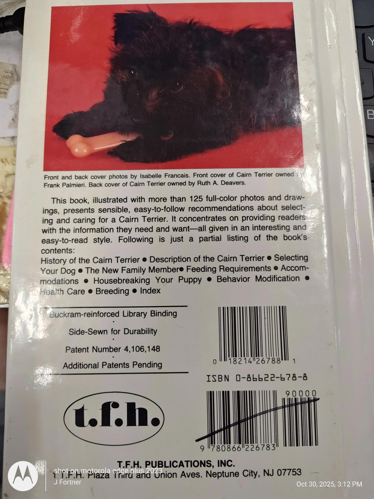 Cairn Terrier book cover featuring a black Cairn Terrier with a toy, showcasing care tips and breed information.