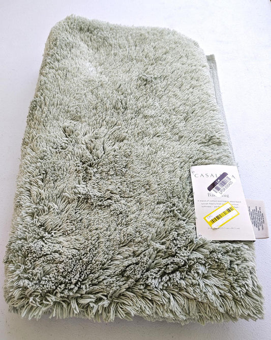 Casablanca plush bath mat in soft green color with a fluffy texture.