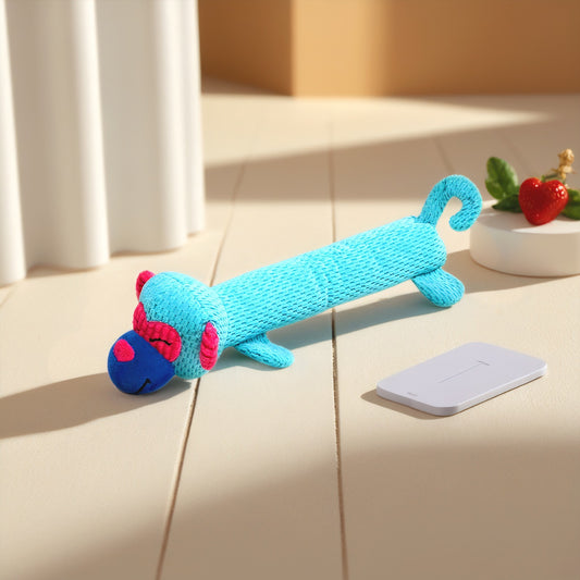 Colorful monkey plush toy in blue and pink, lying on a wooden surface.