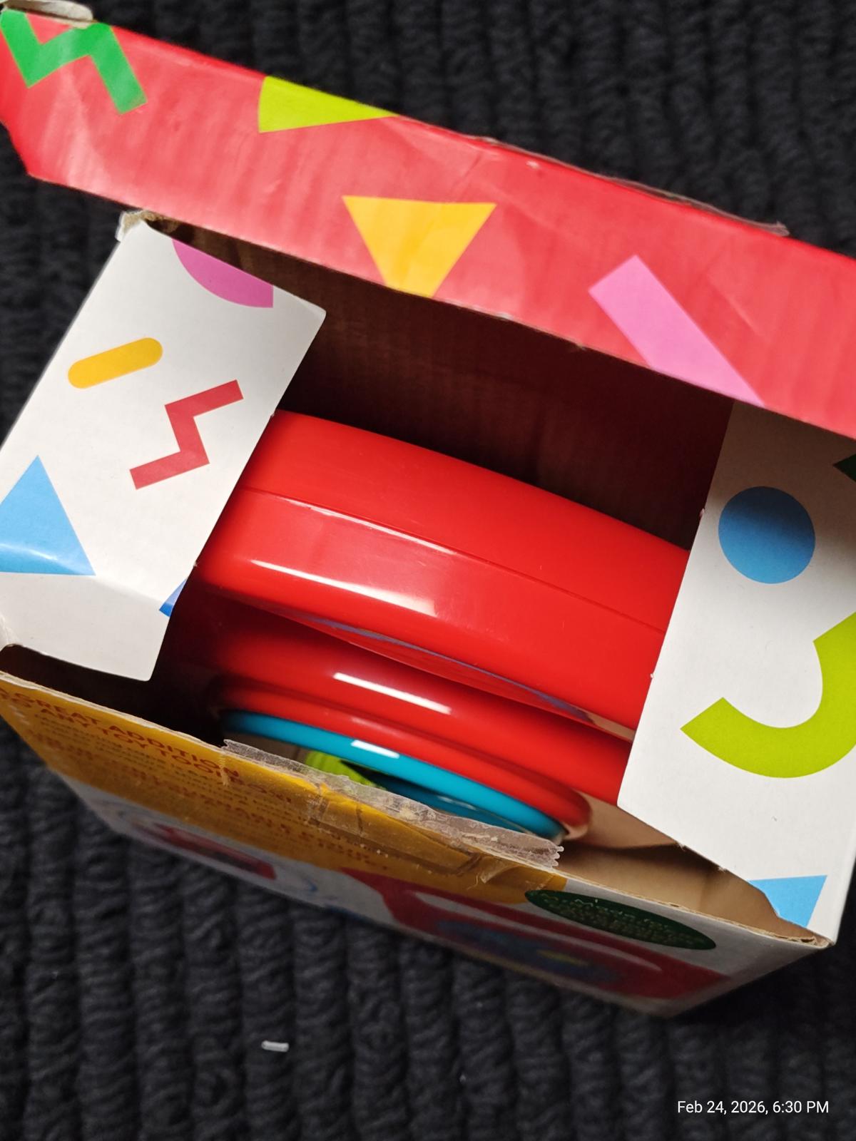 Colorful stacking toy set with red rings in a vibrant box.