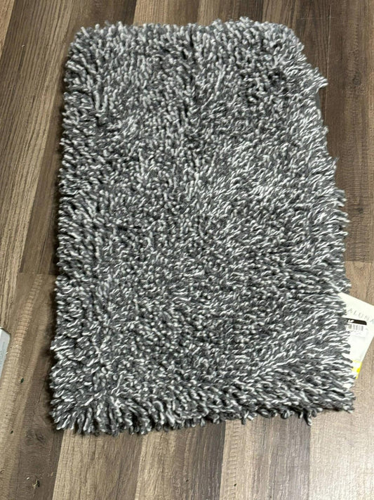 Gray shaggy bath mat with a soft texture and plush fibers.
