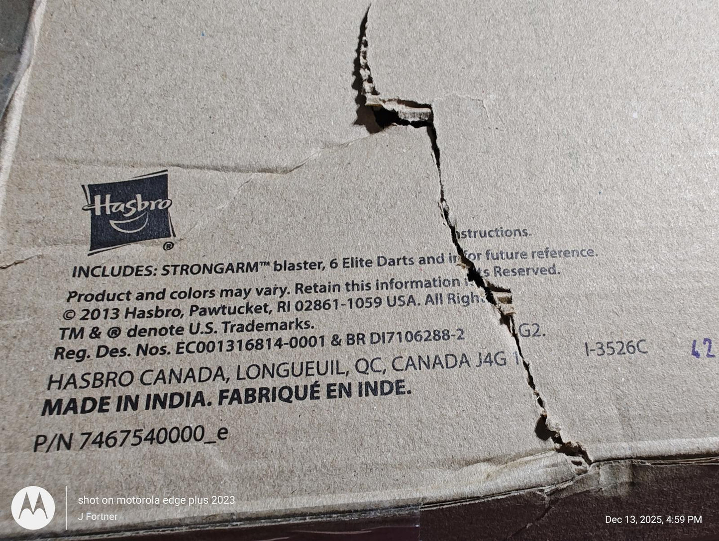 Hasbro Strongarm blaster packaging with visible damage and manufacturing details.