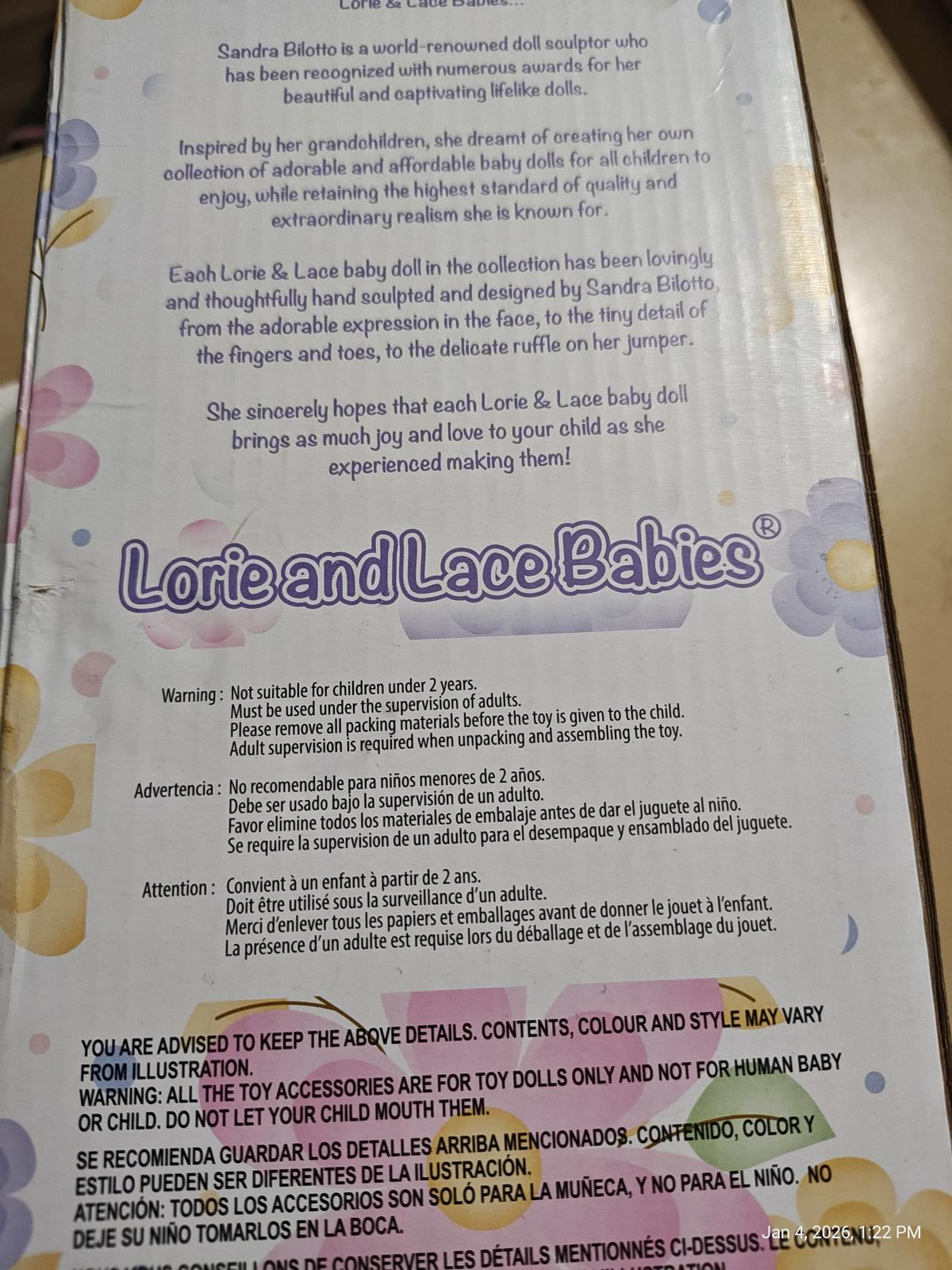 Lorie and Lace Babies doll packaging featuring colorful floral design and safety information.