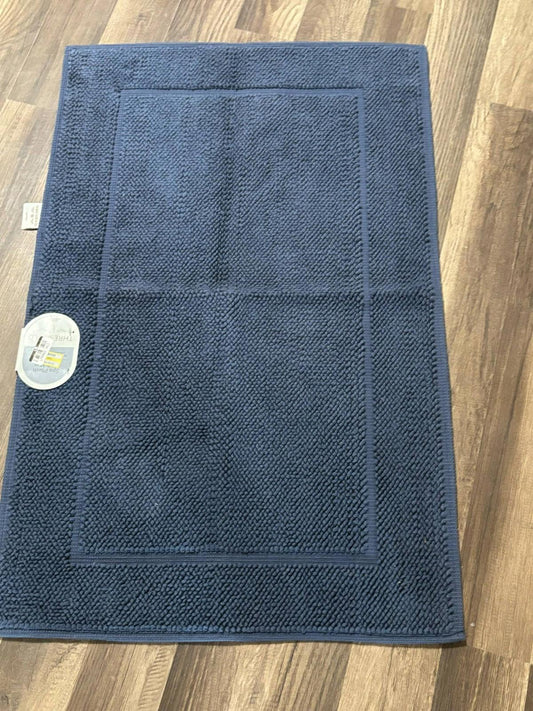 Navy bath mat with textured surface and bordered design for enhanced comfort.