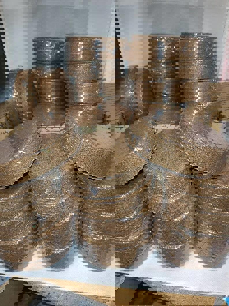 Organic Coconut Coir Discs for gardening, stacked and wrapped in plastic.