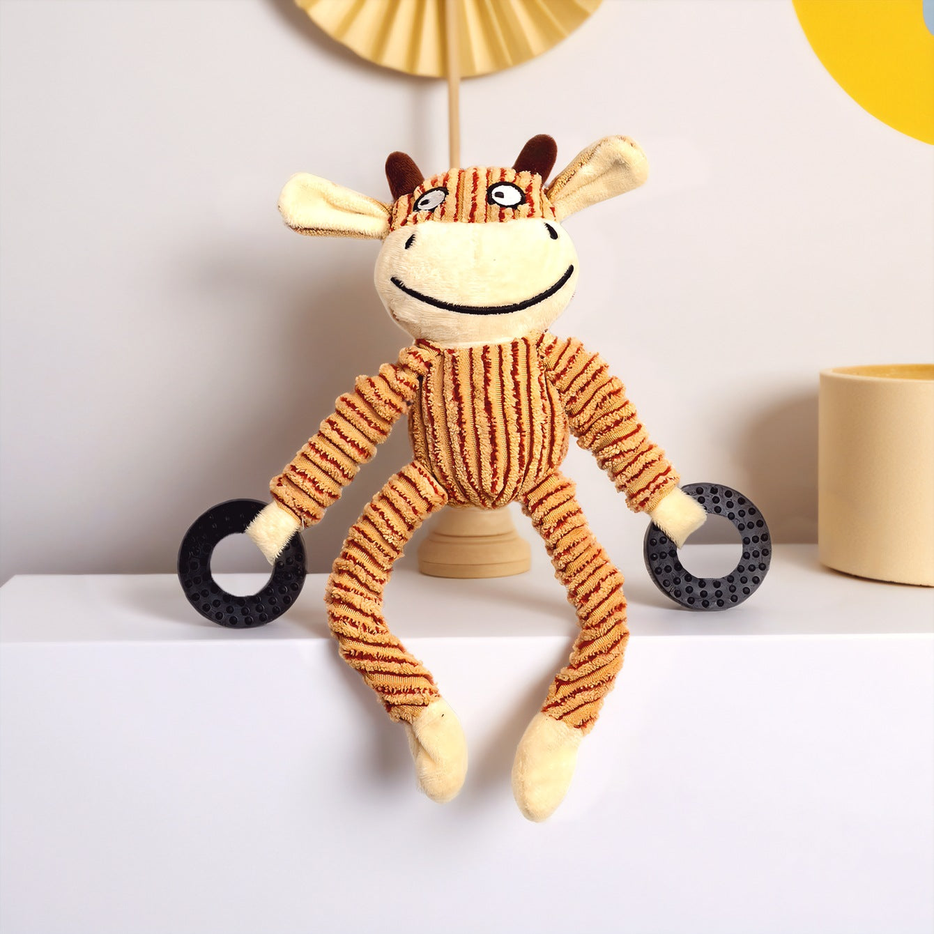 Plush Cow Toy with Striped Pattern and Black Rings in Hands.