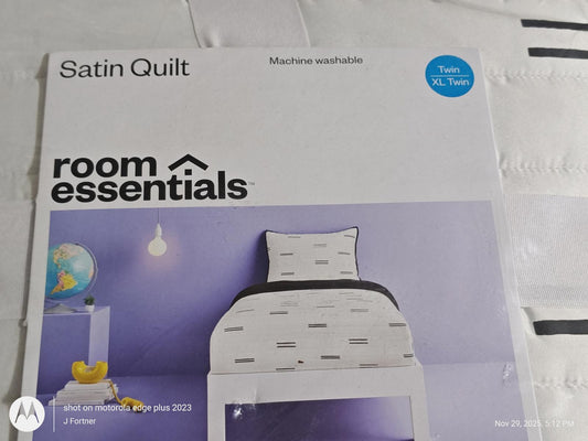 Room Essentials Satin Quilt featuring a modern design with black and white patterns.