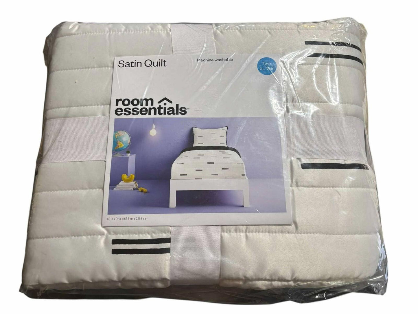 Room Essentials satin quilt featuring a white design with black stripes, perfect for bedding.