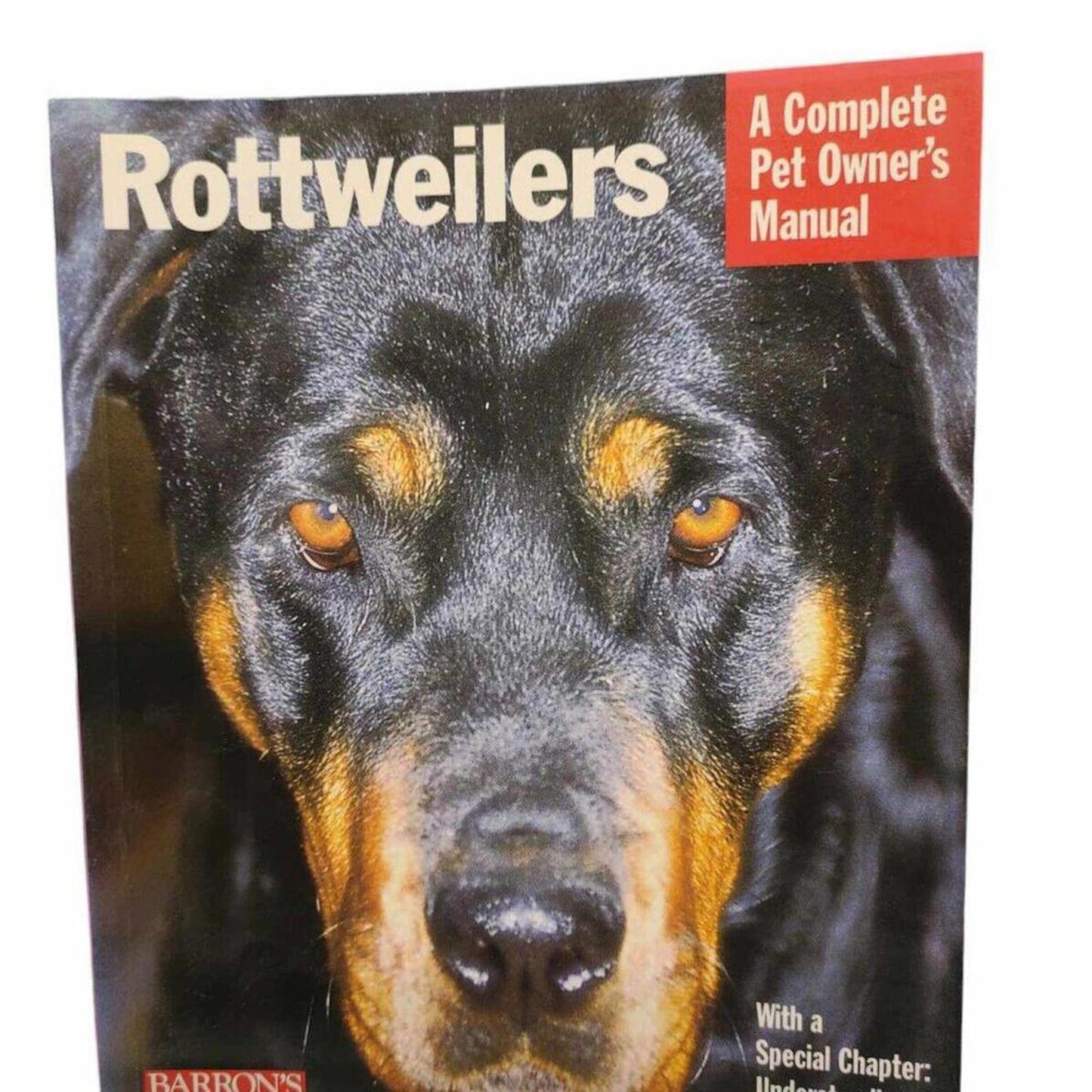 Rottweilers manual featuring a close-up of a Rottweiler's face with striking eyes.