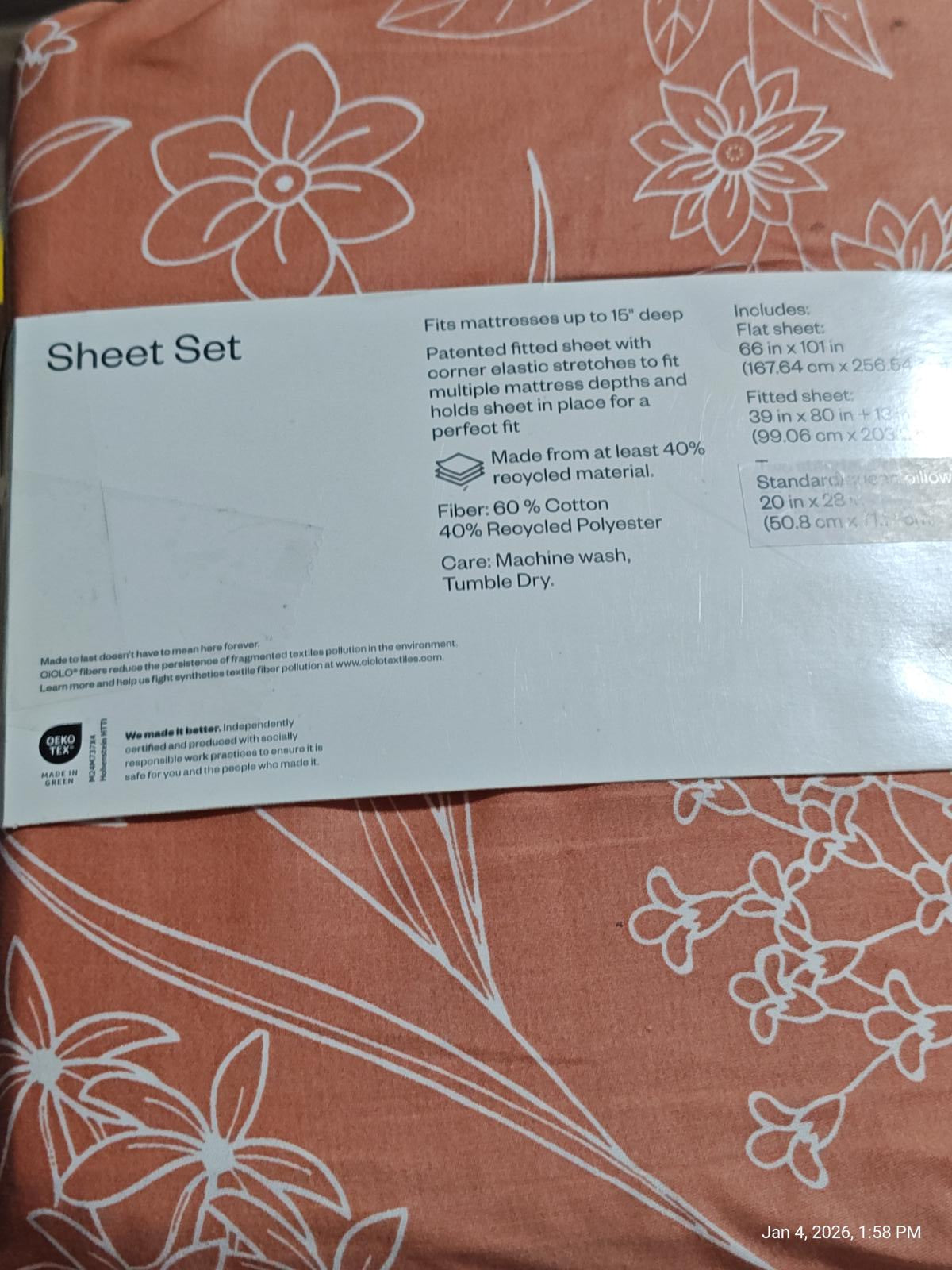 Sheet set featuring a floral design on a coral background, made from 60% cotton and 40% recycled polyester.