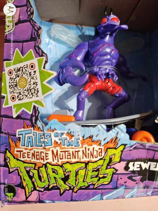 Tales of the Teenage Mutant Ninja Turtles action figure in purple with skateboard and red shorts.