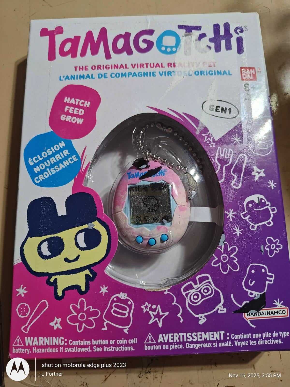 Tamagotchi virtual pet toy in pink packaging with character design and growth features.