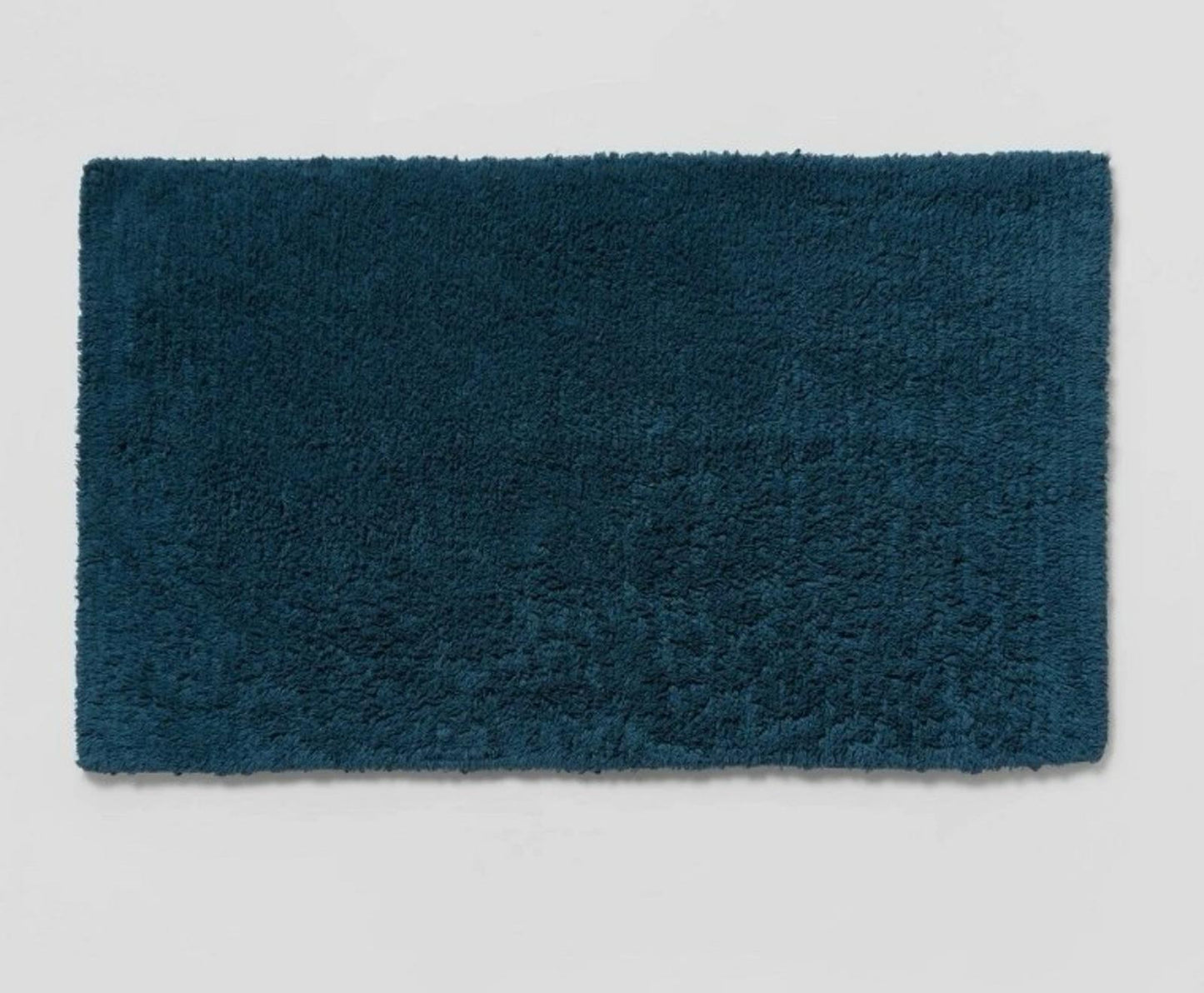 Teal bath mat with a plush texture, perfect for adding comfort to your bathroom.