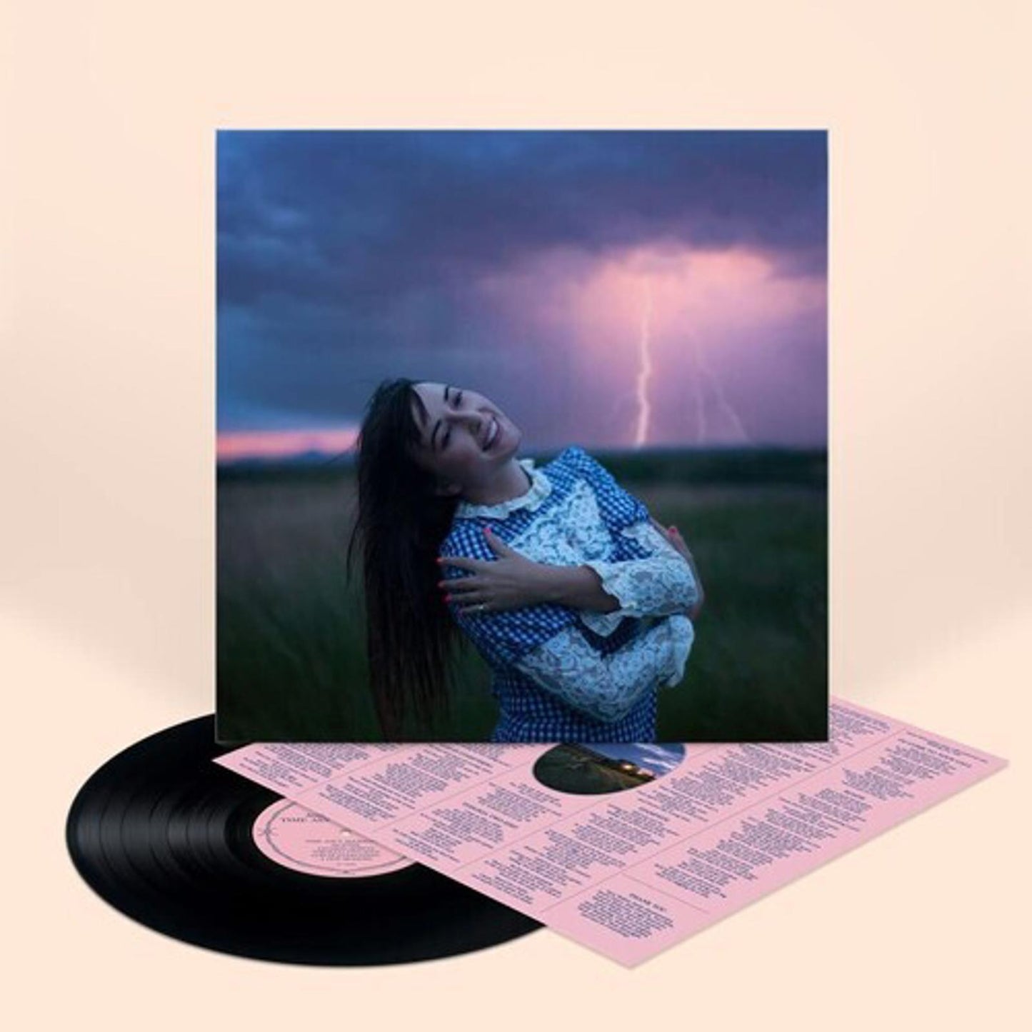 Vinyl record featuring a woman smiling in a field with a stormy sky background.