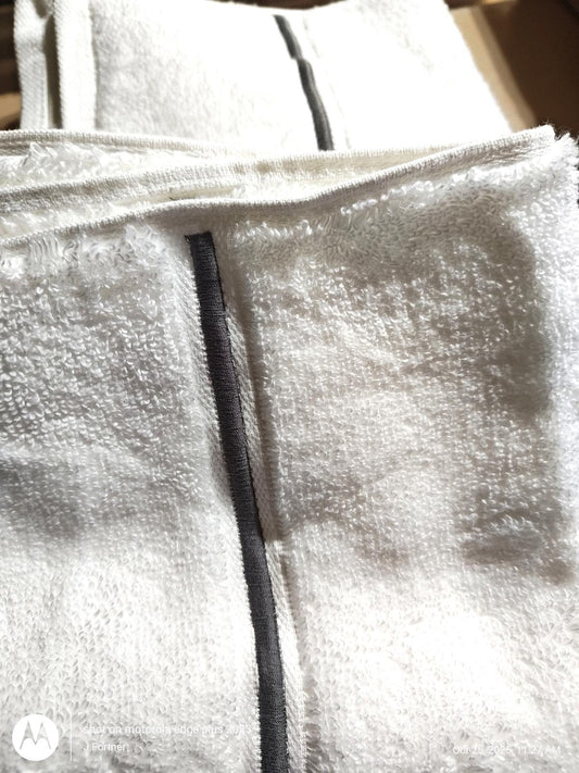 White bath towels with gray stitching detail, soft and absorbent.