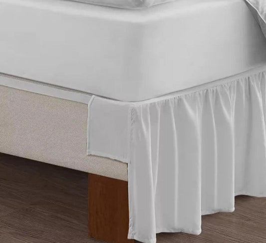 White bed skirt with ruffled edges, enhancing the bed's appearance.