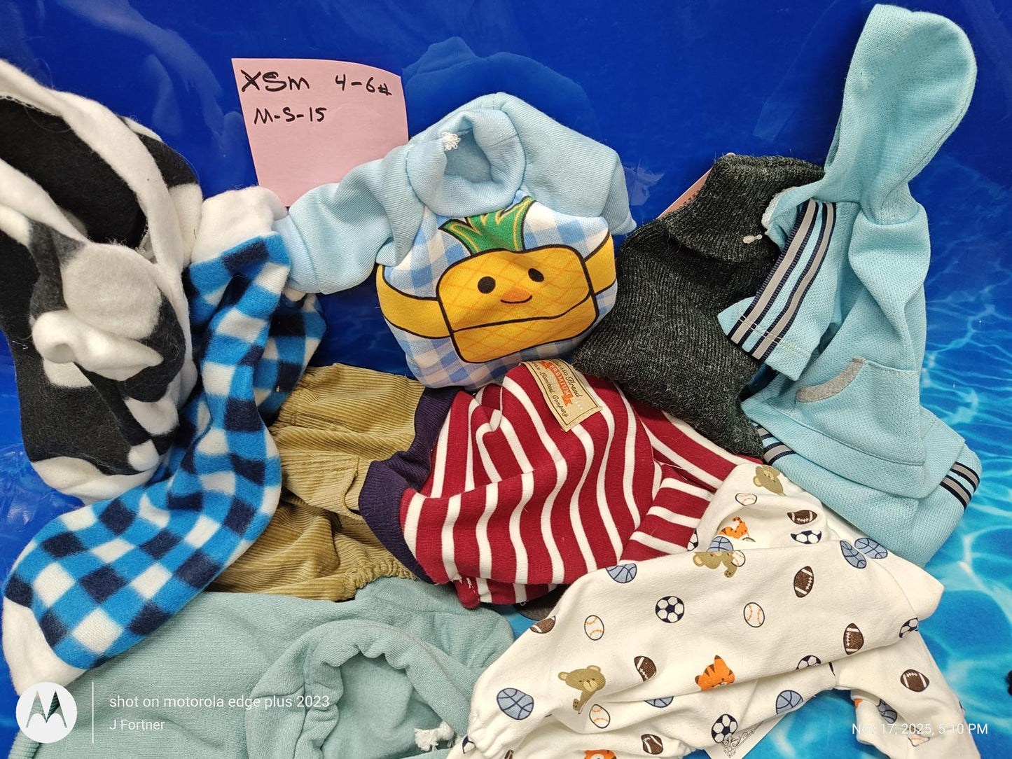 XSM v-16 baby clothes assortment featuring playful designs and colors.