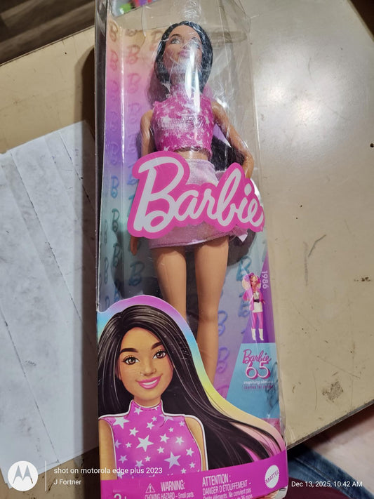 Barbie doll in a pink outfit with a star design, packaged in a colorful box.