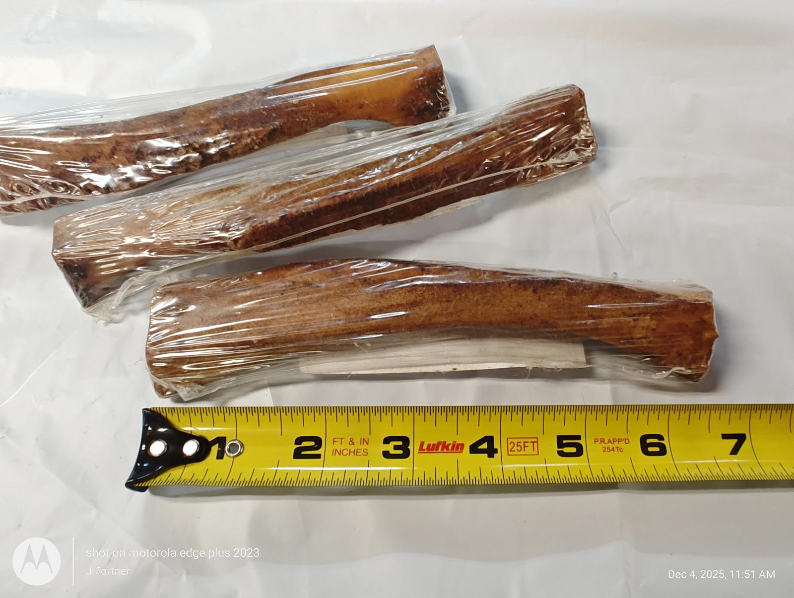 Dog chew bones packaged in plastic, measuring approximately 6 inches long.