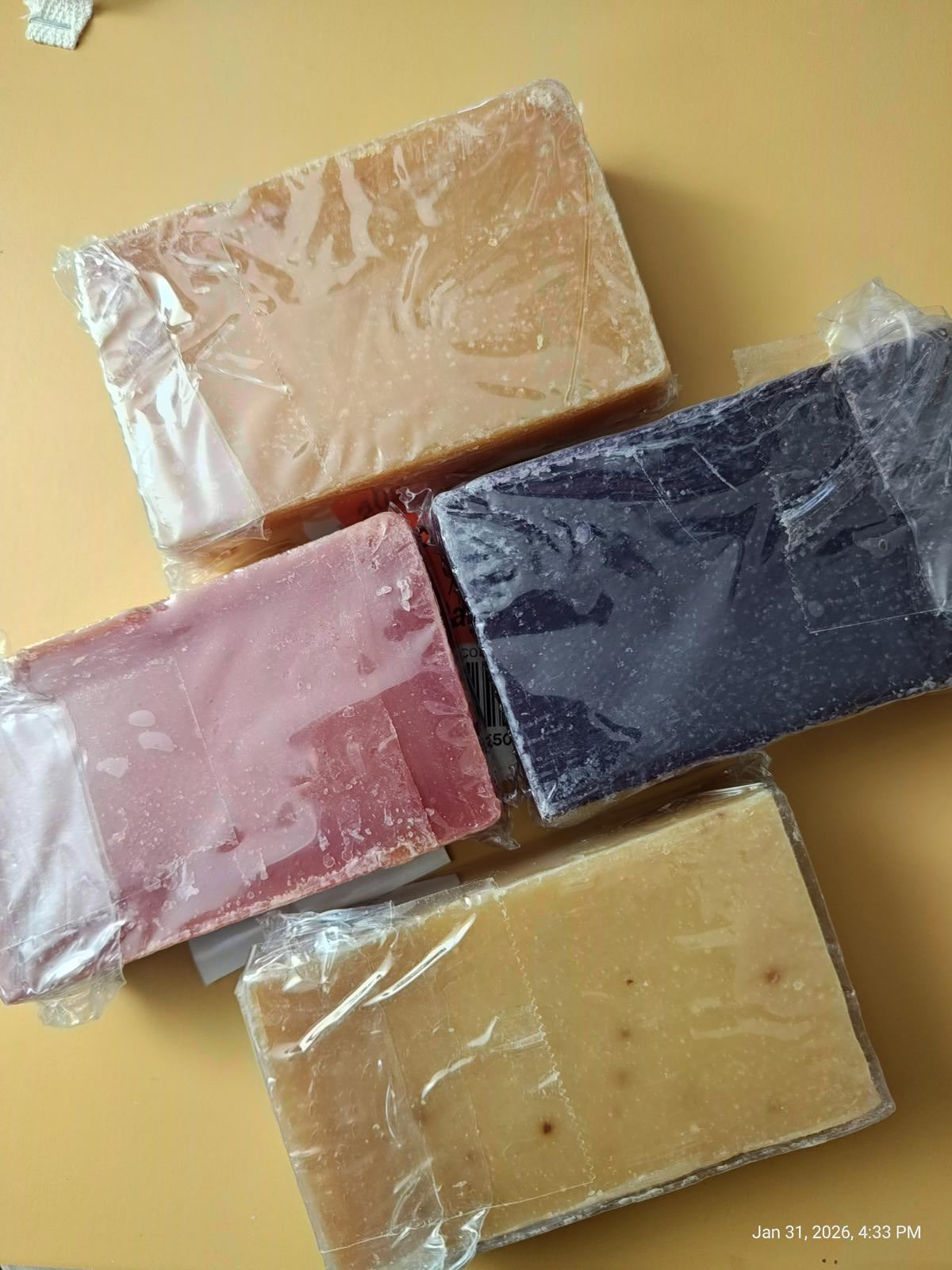 Natural Soap Bars in various colors including pink, purple, and beige, wrapped in clear packaging.