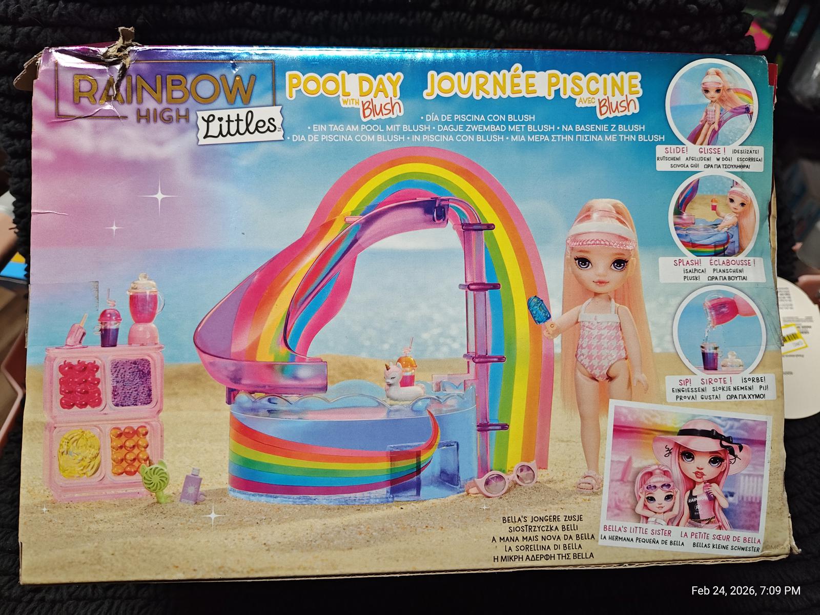 Rainbow High Pool Day playset featuring a colorful rainbow arch and doll accessories.