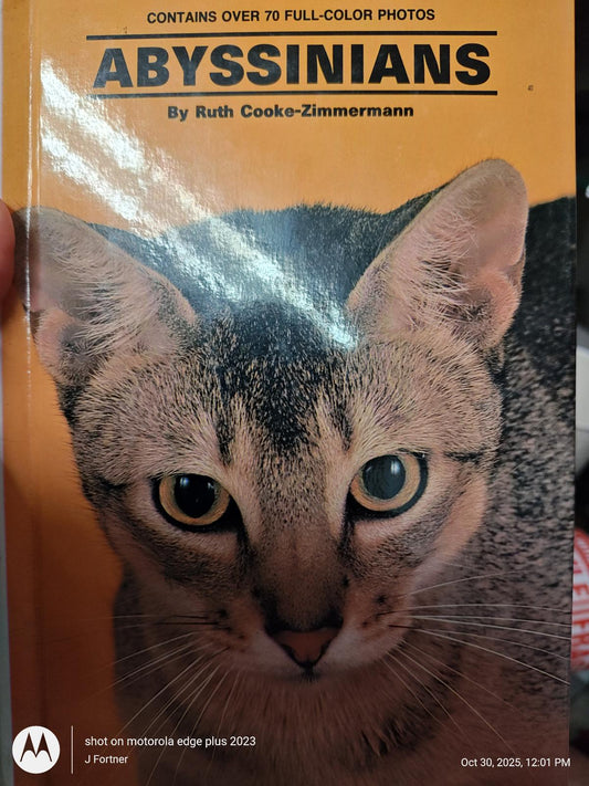 Abyssinians book cover featuring a close-up of a cat's face with striking green eyes.