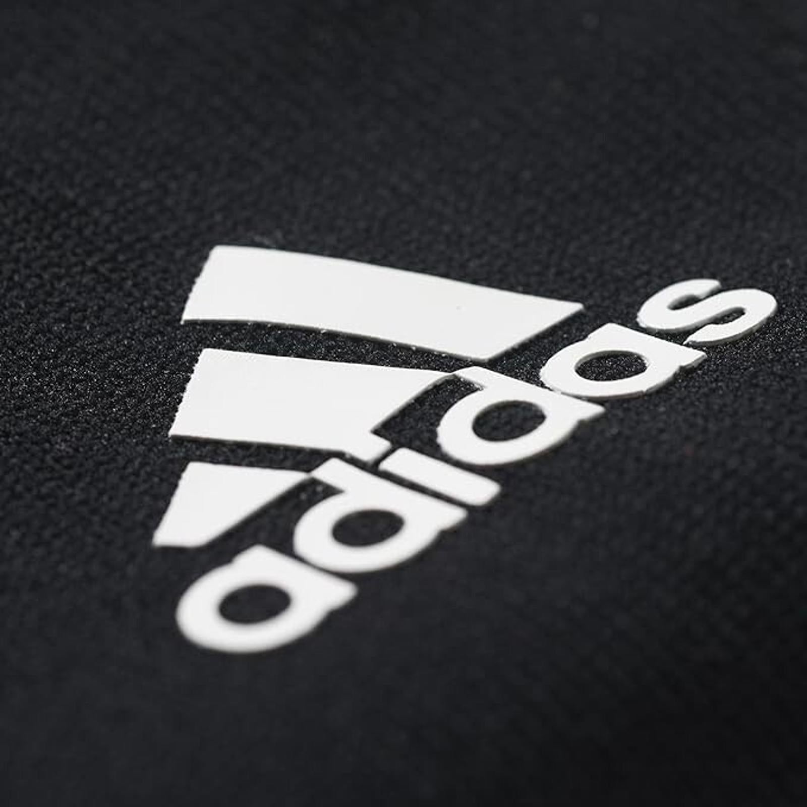 Adidas logo on a black fabric background, showcasing the iconic three stripes design.