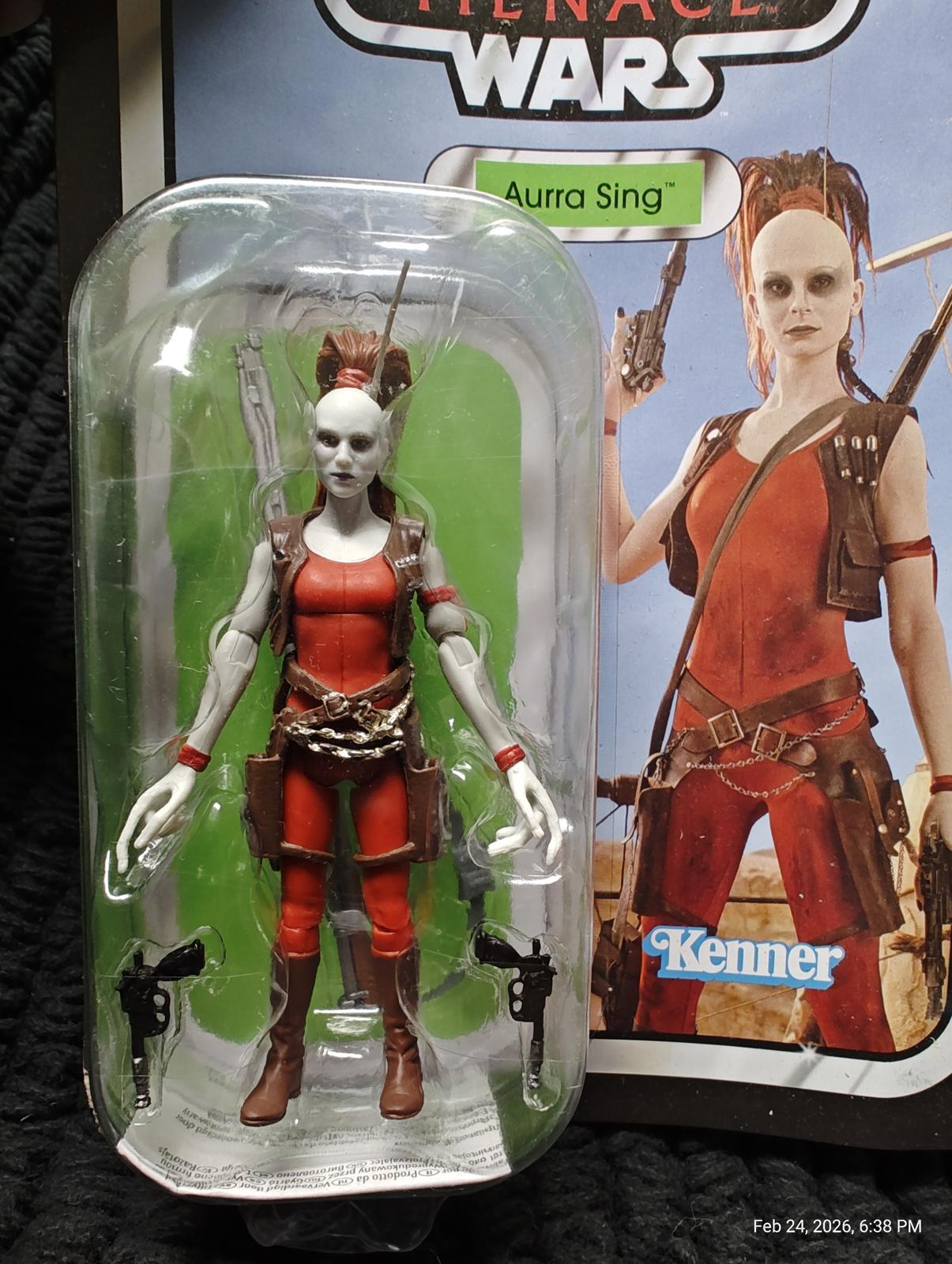 Aurra Sing action figure in red outfit with accessories and packaging.