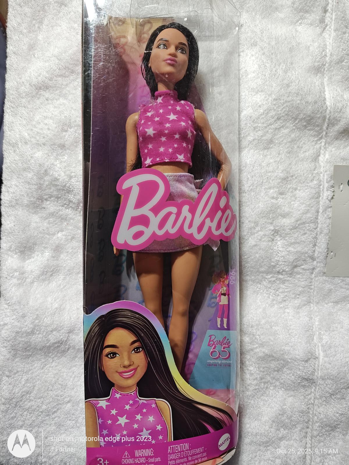 Barbie doll in a pink star-patterned outfit, featuring long dark hair and a stylish look.