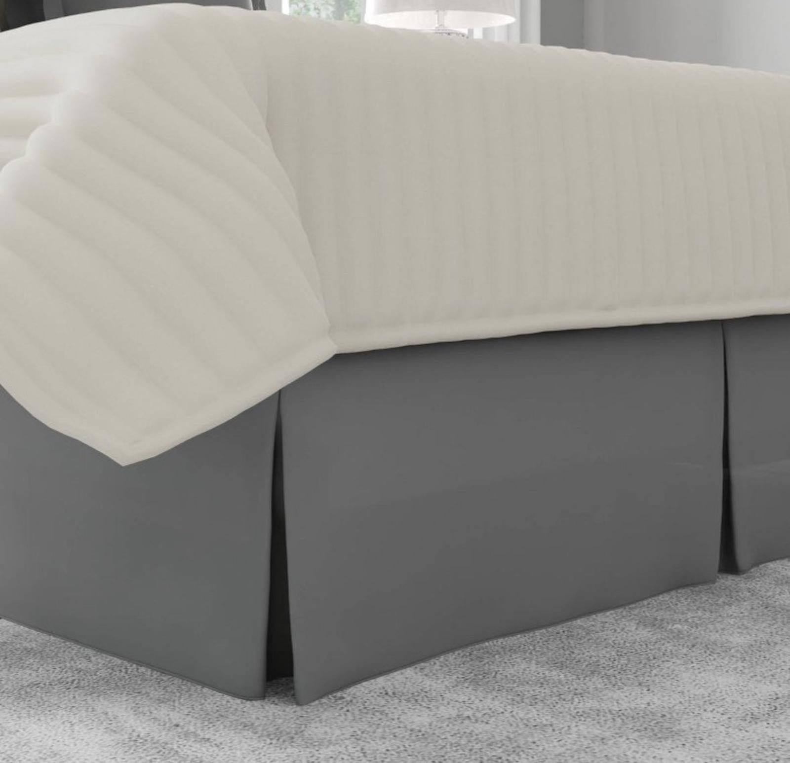 Bed skirt in gray color with a cream-colored quilted top layer.