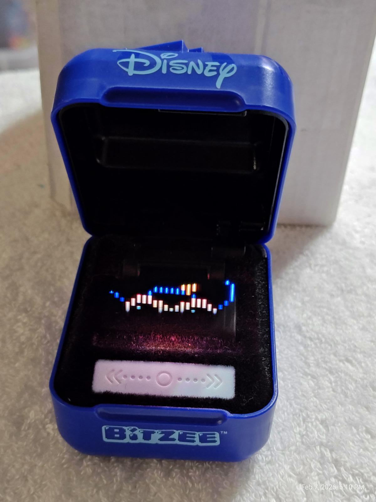 Disney Bitzee toy in a blue case, featuring colorful LED lights and a sleek design.