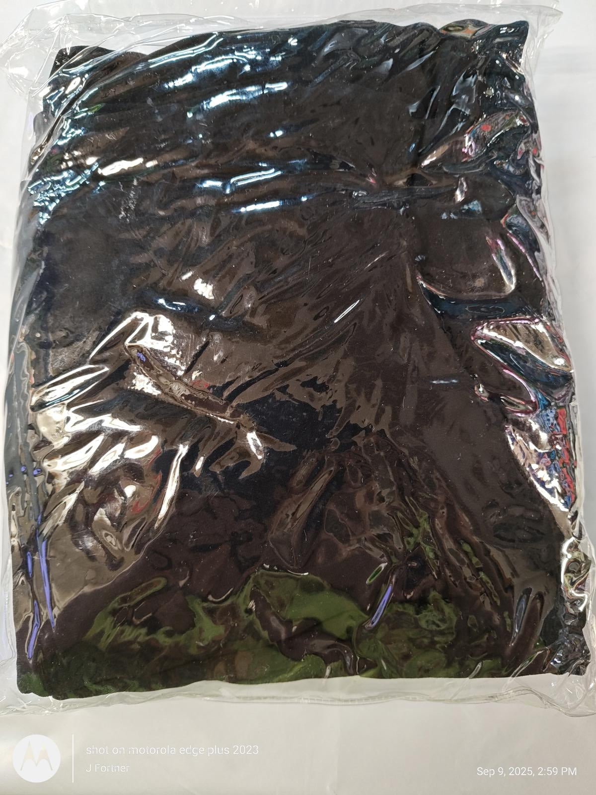 Black fleece blanket packaged in plastic for easy storage.