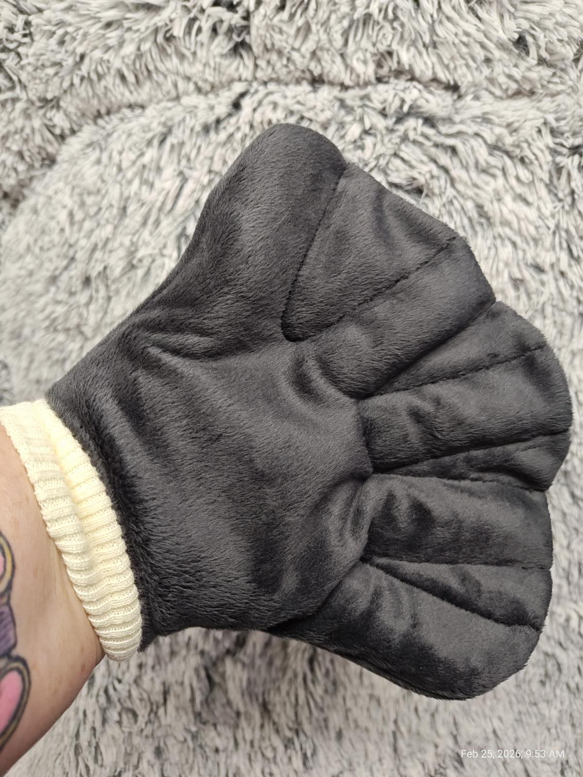 Soft black oven mitt with a textured grip for easy handling.