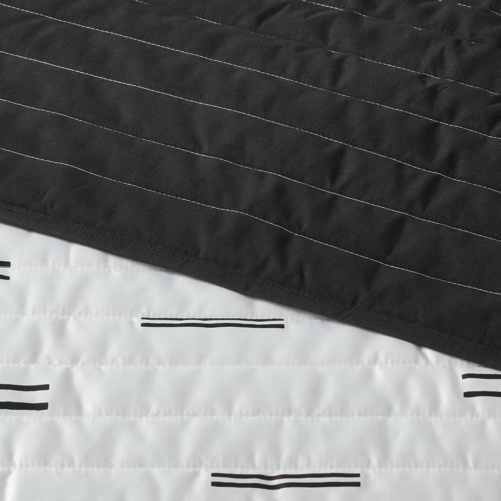 Black and white striped quilt featuring a modern design with contrasting colors.