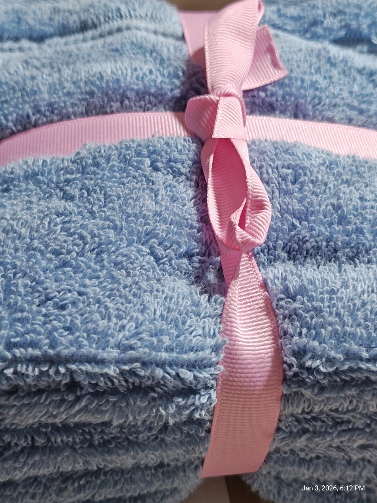 Blue microfiber towels neatly stacked and tied with a pink ribbon.