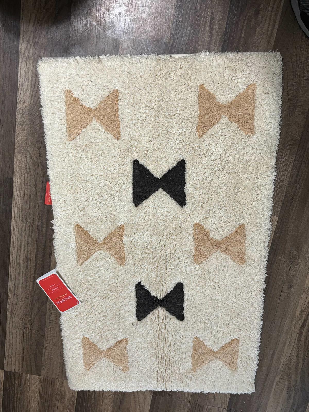 Bow Pattern Area Rug featuring beige and black bows on a cream background.