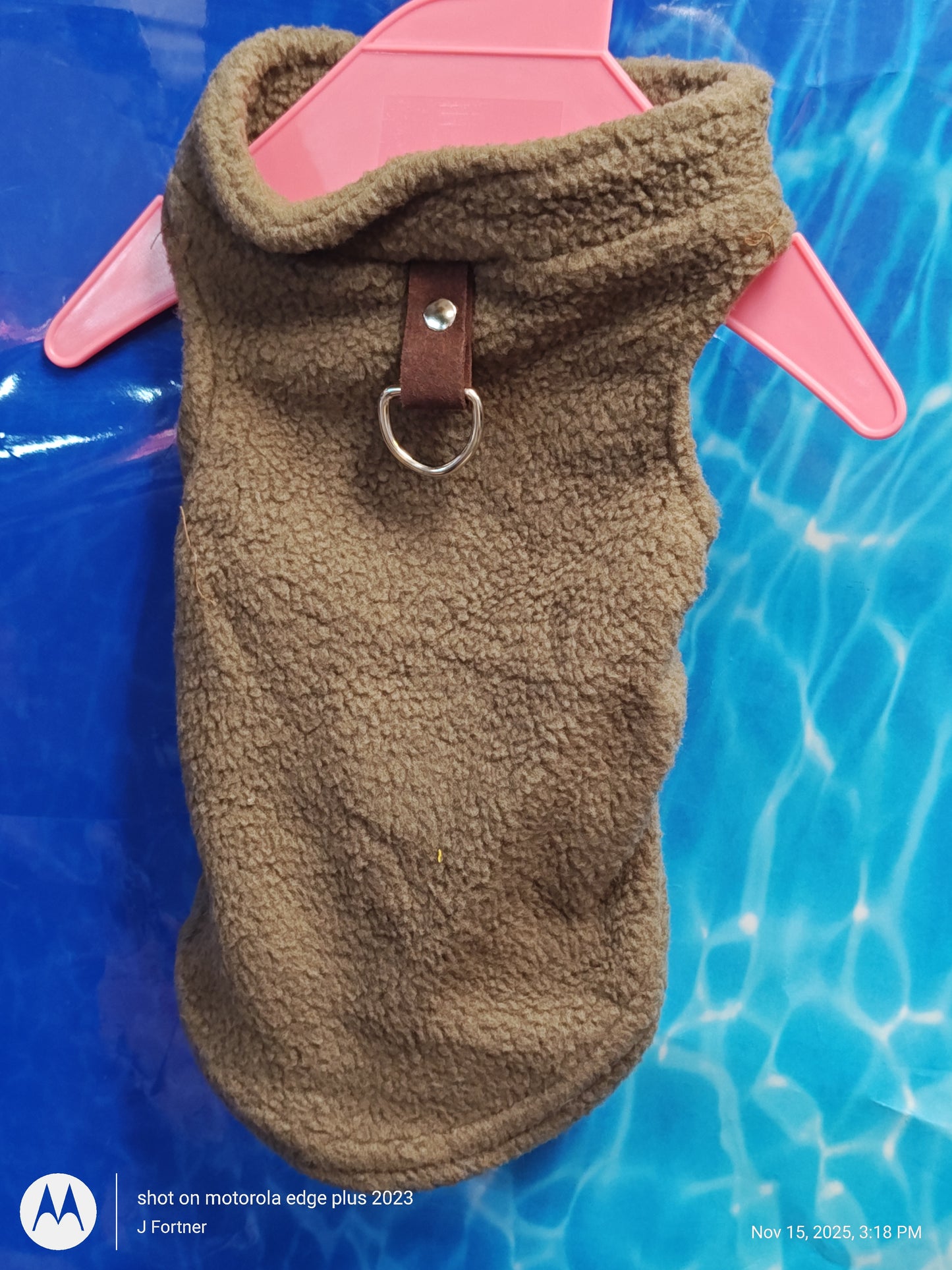 Brown fleece dog vest with a collar and metal ring for leash attachment.