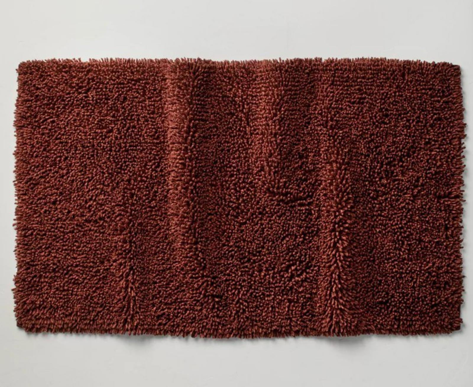 Brown shaggy bath mat with a soft texture and plush surface.