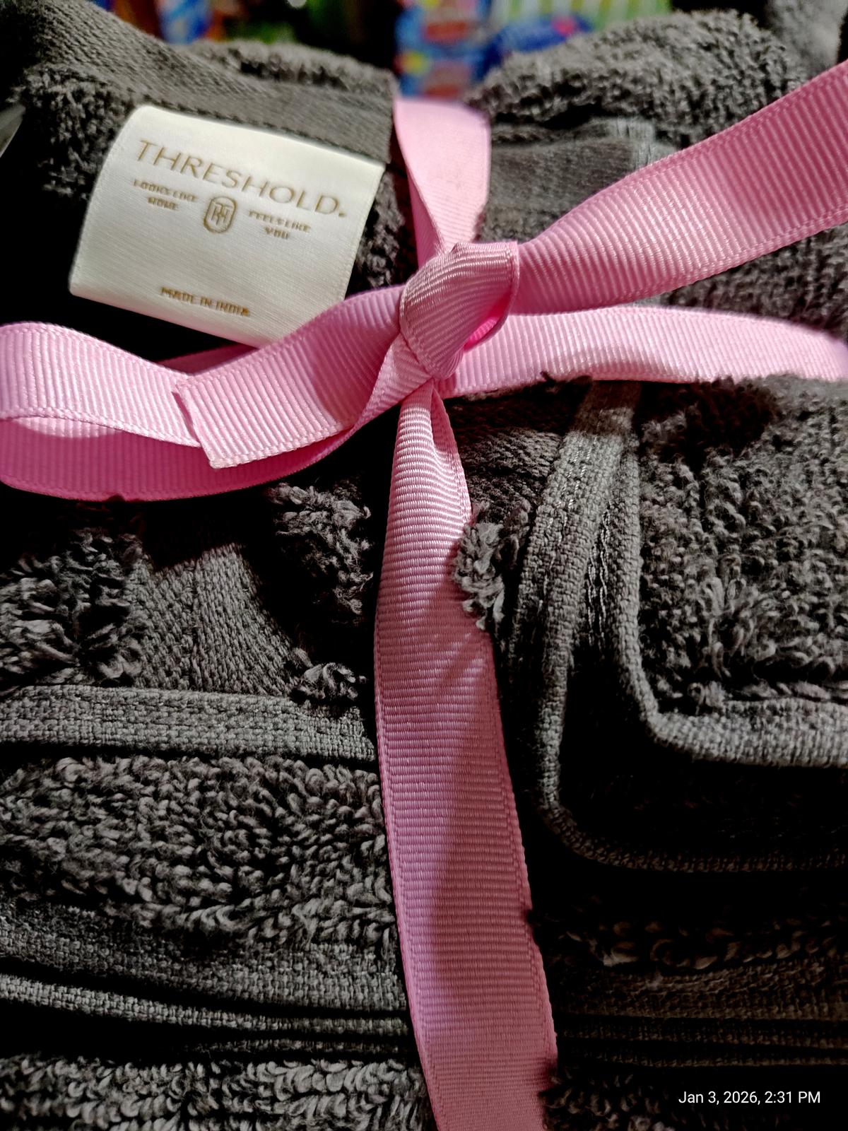 Threshold gray bath towels tied with a pink ribbon, showcasing soft texture and quality.