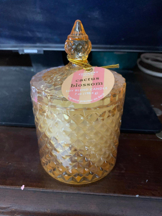 Cactus Blossom candle in a decorative amber glass jar with a diamond pattern.