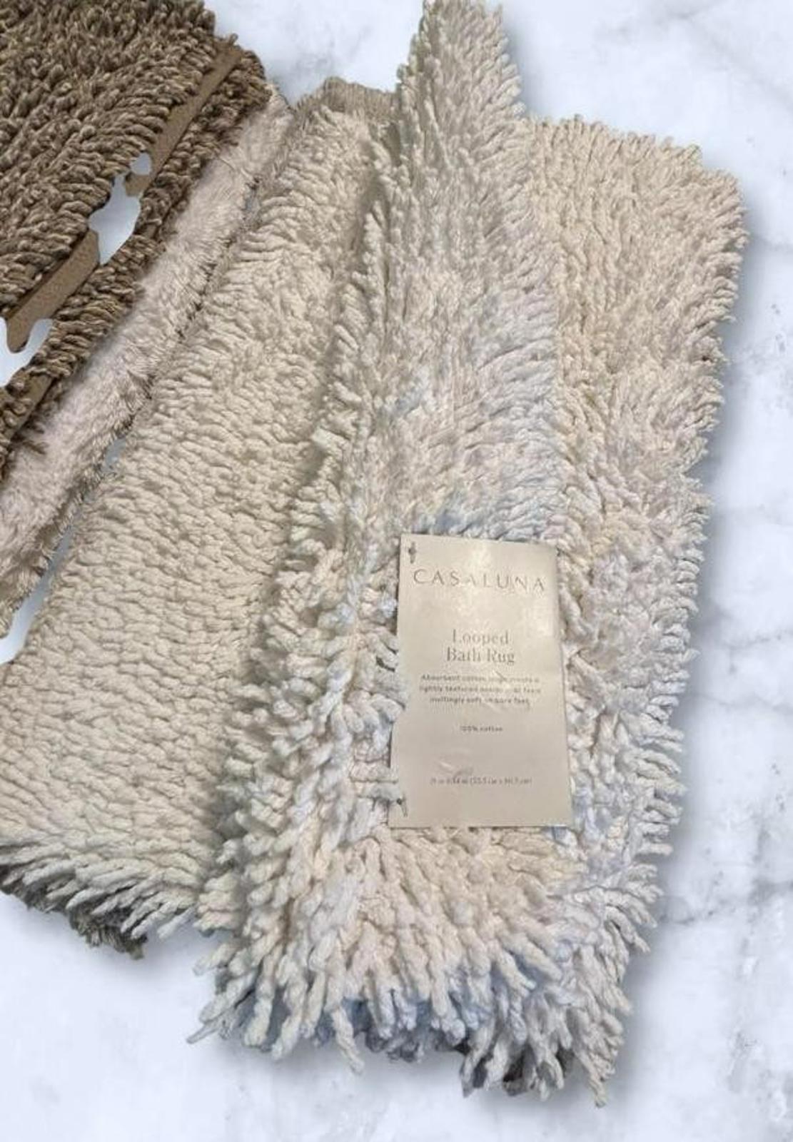 Casafina bath rug in soft beige color with plush texture and label visible.