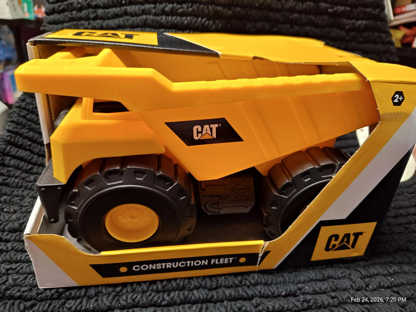 CAT construction fleet toy featuring a yellow dump truck with black wheels.