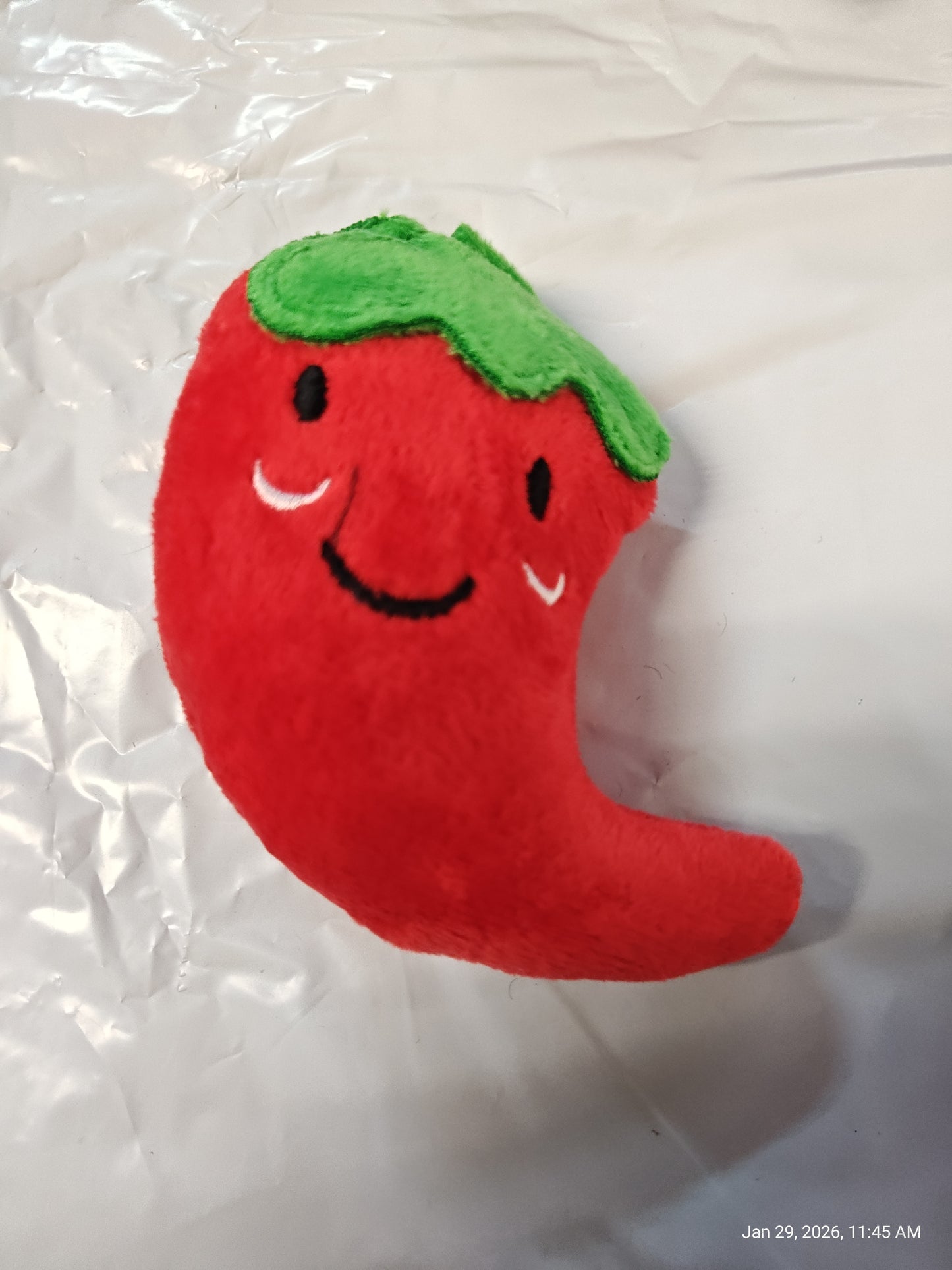 Chili Pepper Plush Toy with a smiling face and green top.