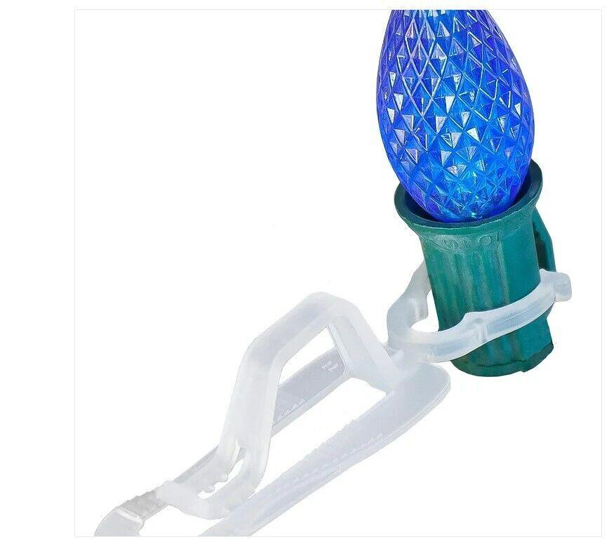 Christmas light clip for securing blue decorative bulbs.