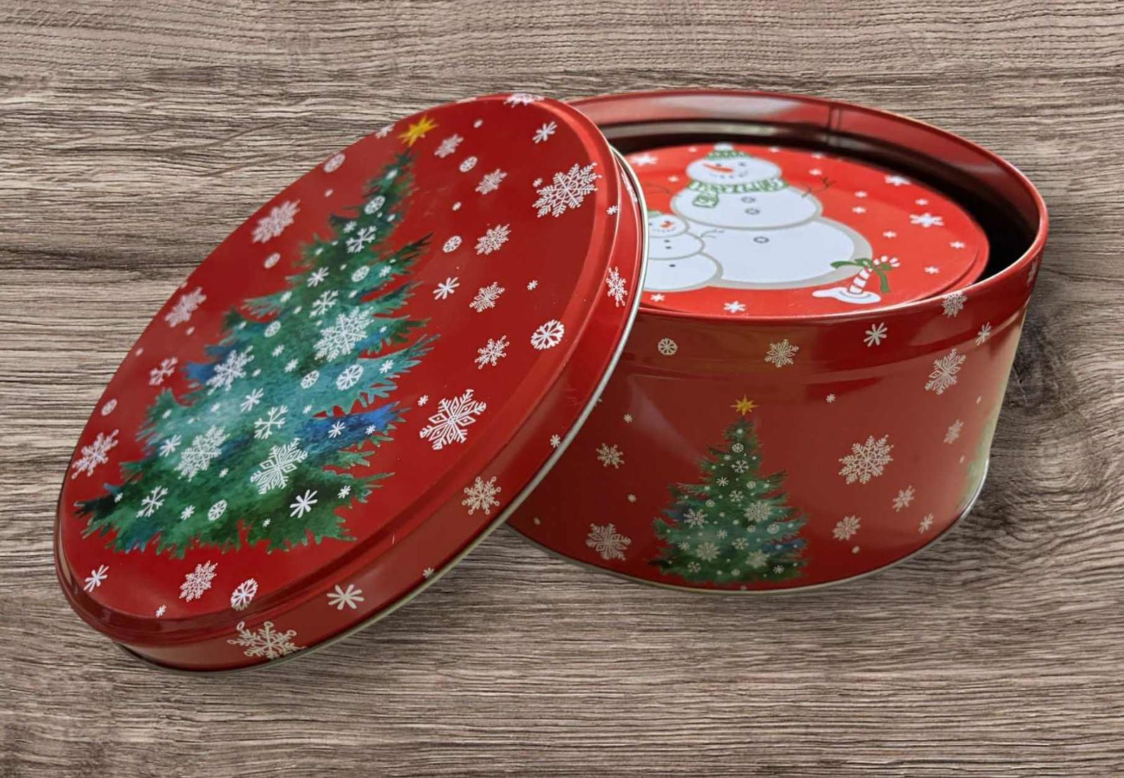 Christmas tin container featuring a red design with snowflakes and a decorated tree.