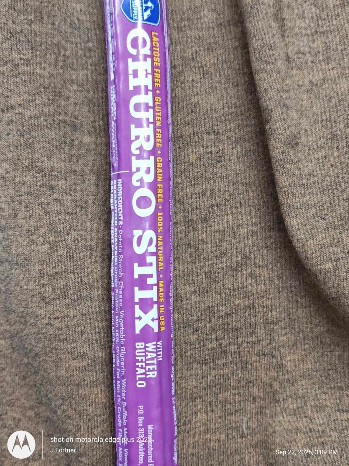 Churro Stix Water Buffalo chew stick with a purple packaging on a brown background.